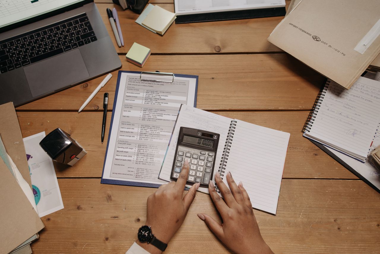 Person reviewing monthly budget showing income and expenses while considering debt review support options